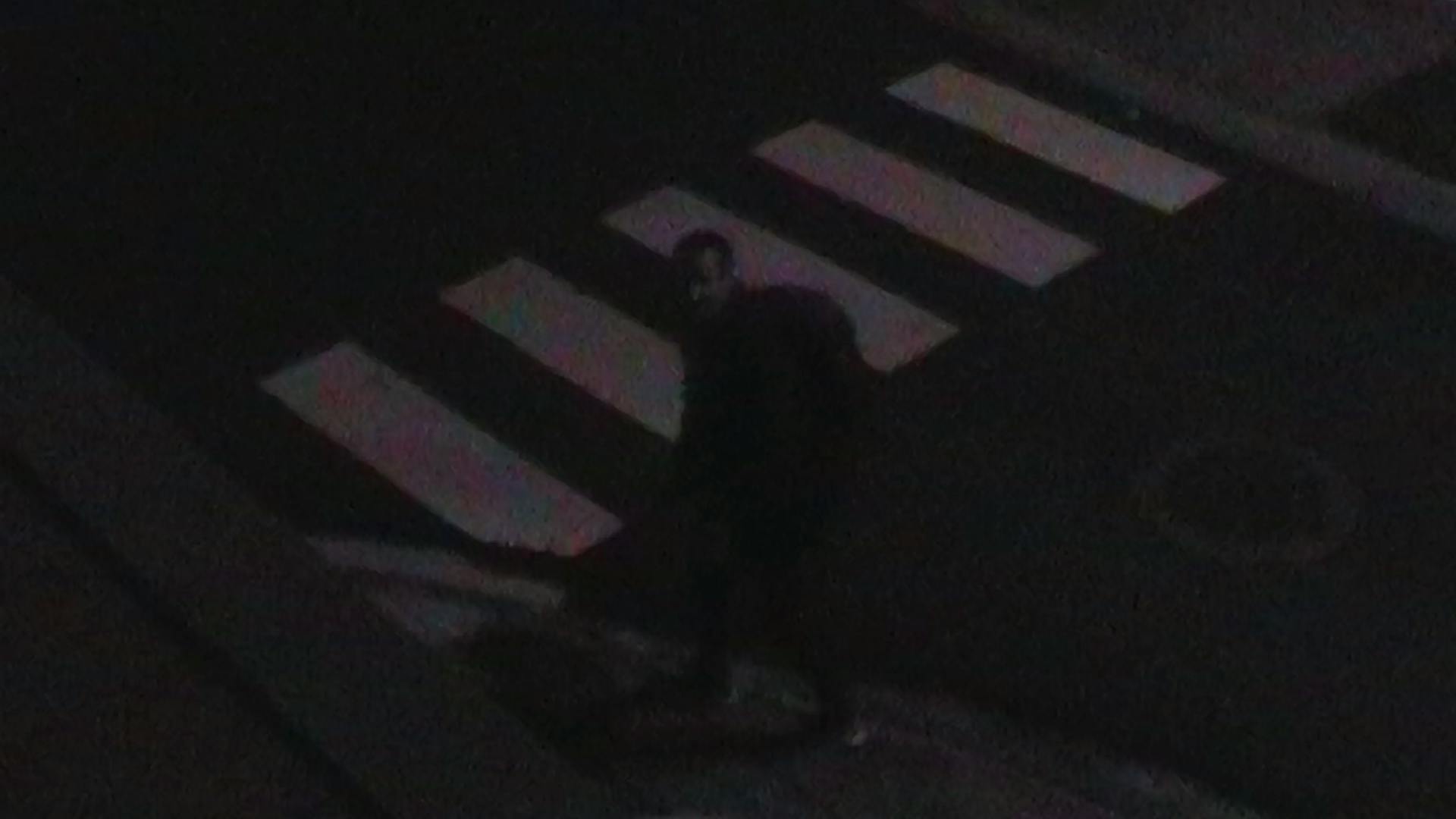 a person walking across a street at night