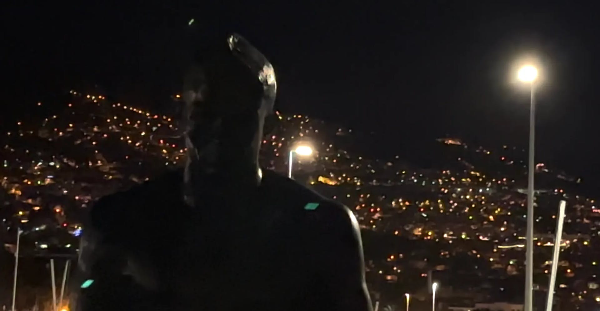 a man standing in front of a city at night