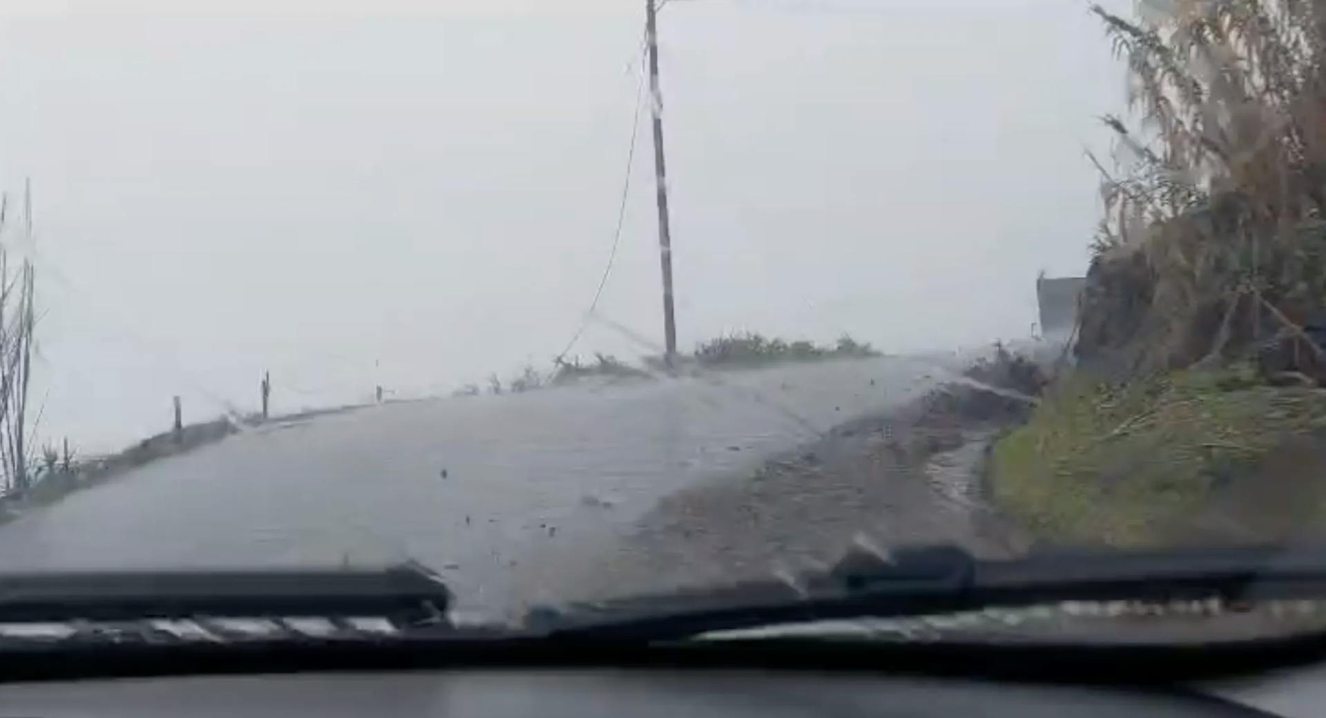 a car driving down a rain soaked road