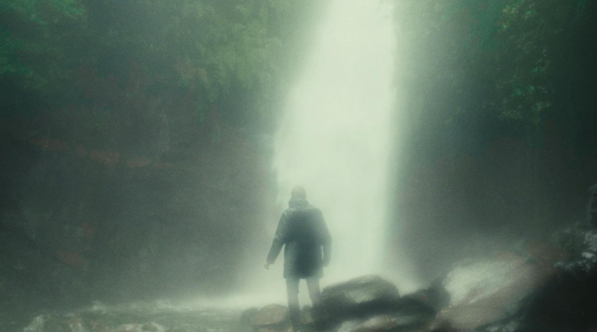 a person standing in front of a waterfall