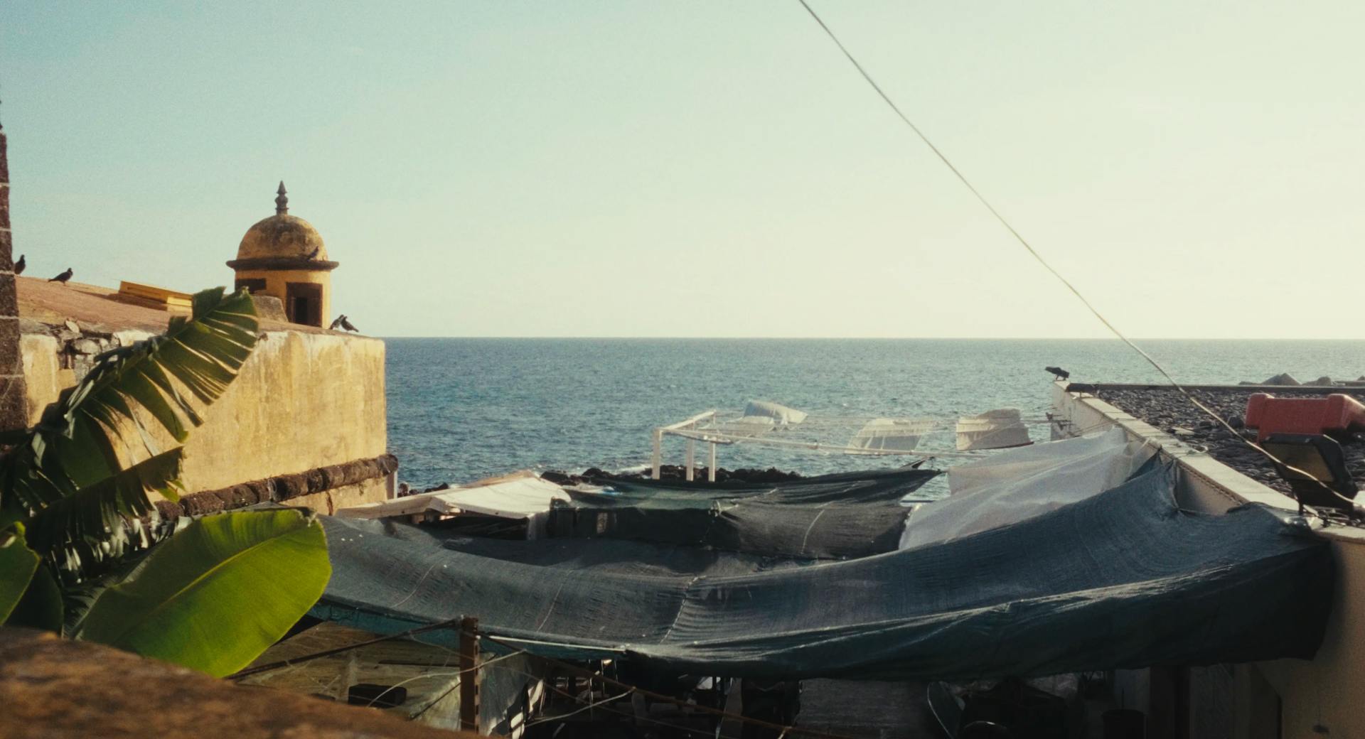 a boat sitting on top of a roof next to the ocean