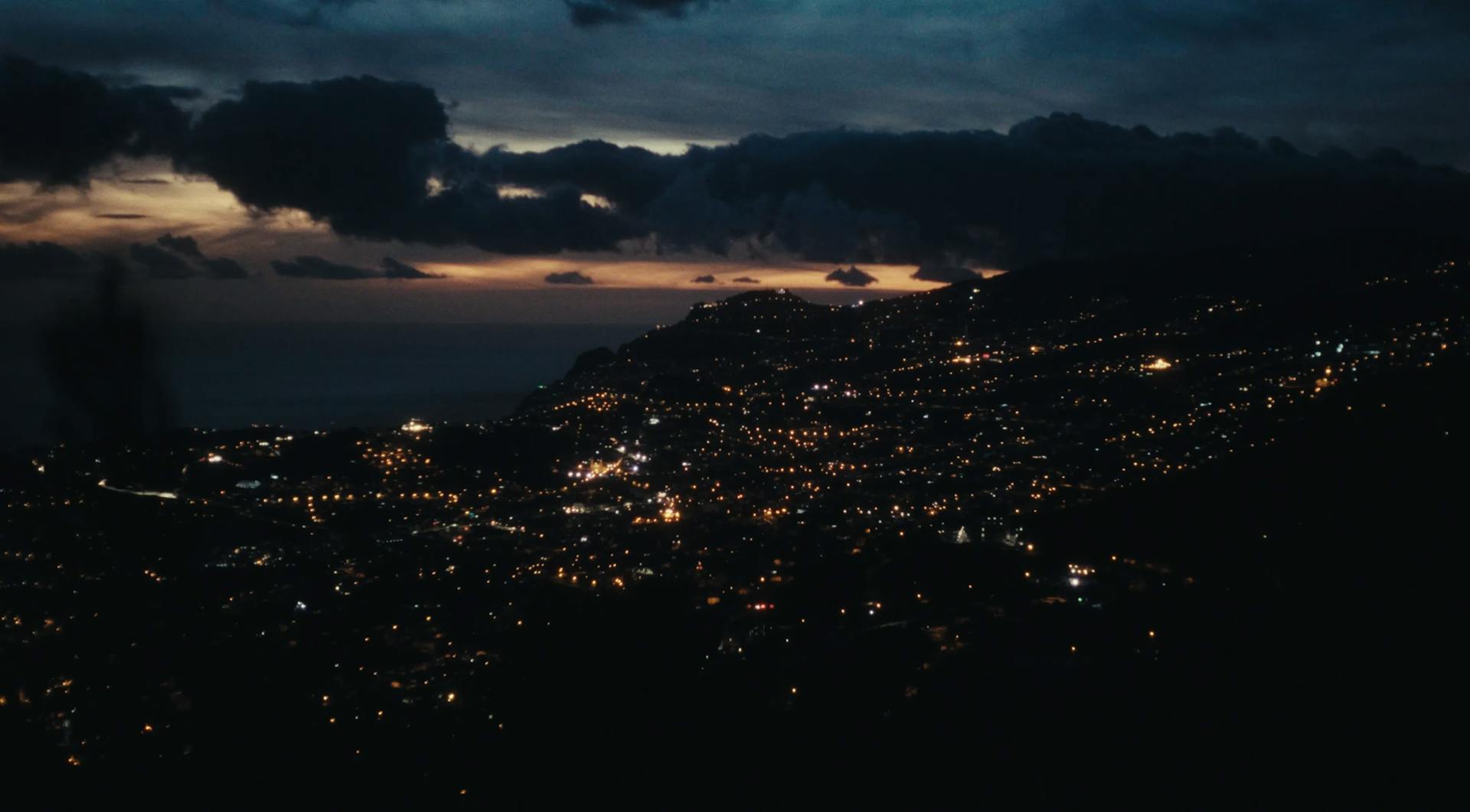 a view of a city at night from the top of a hill