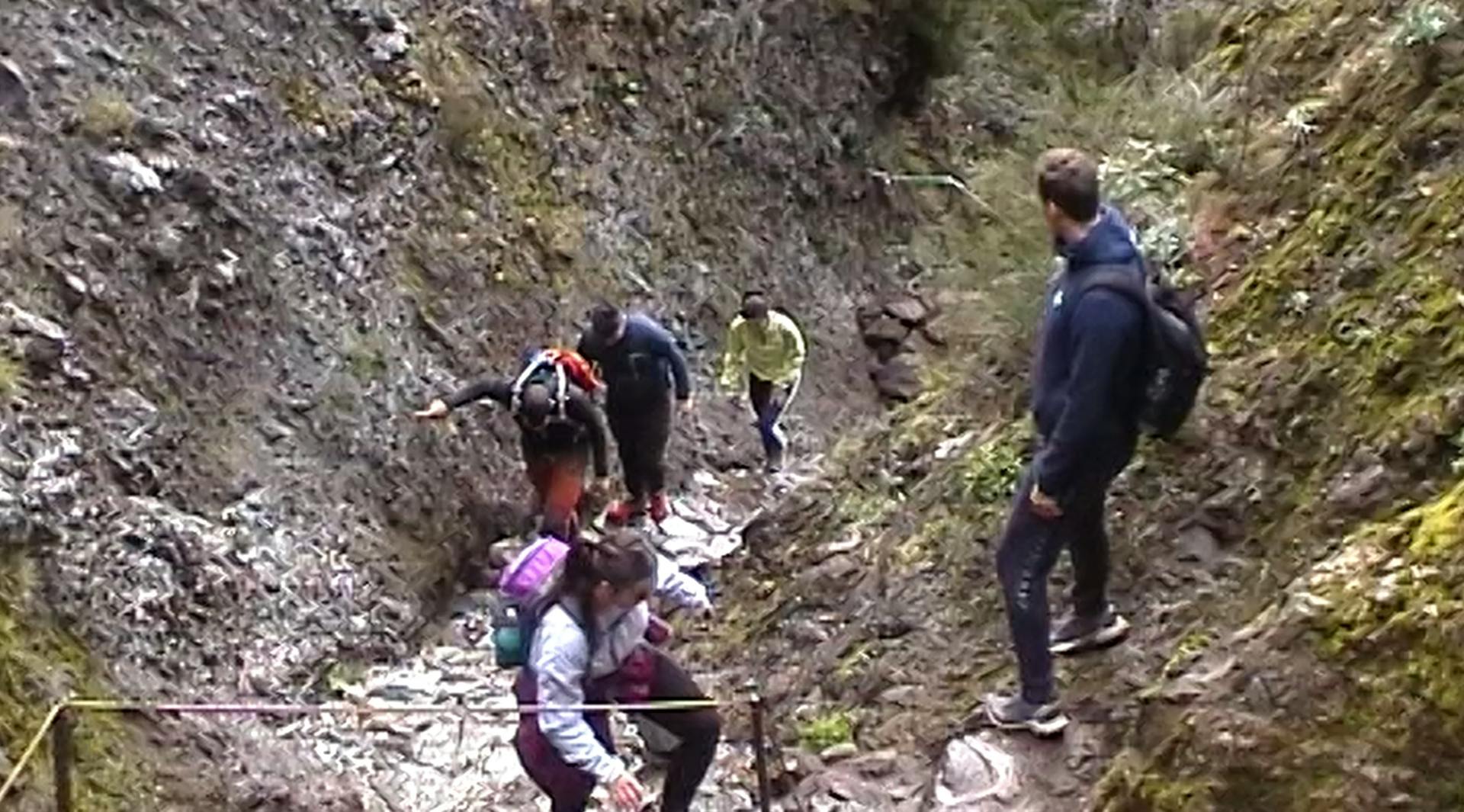 a group of people climbing up a steep hill