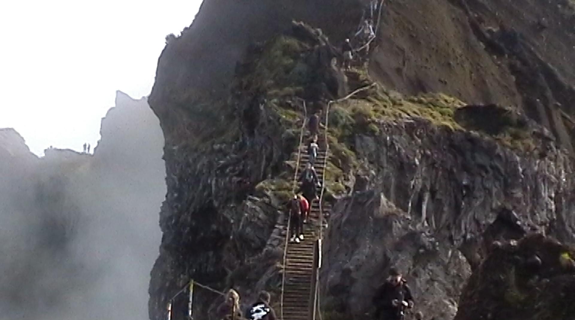 a group of people climbing up a steep mountain