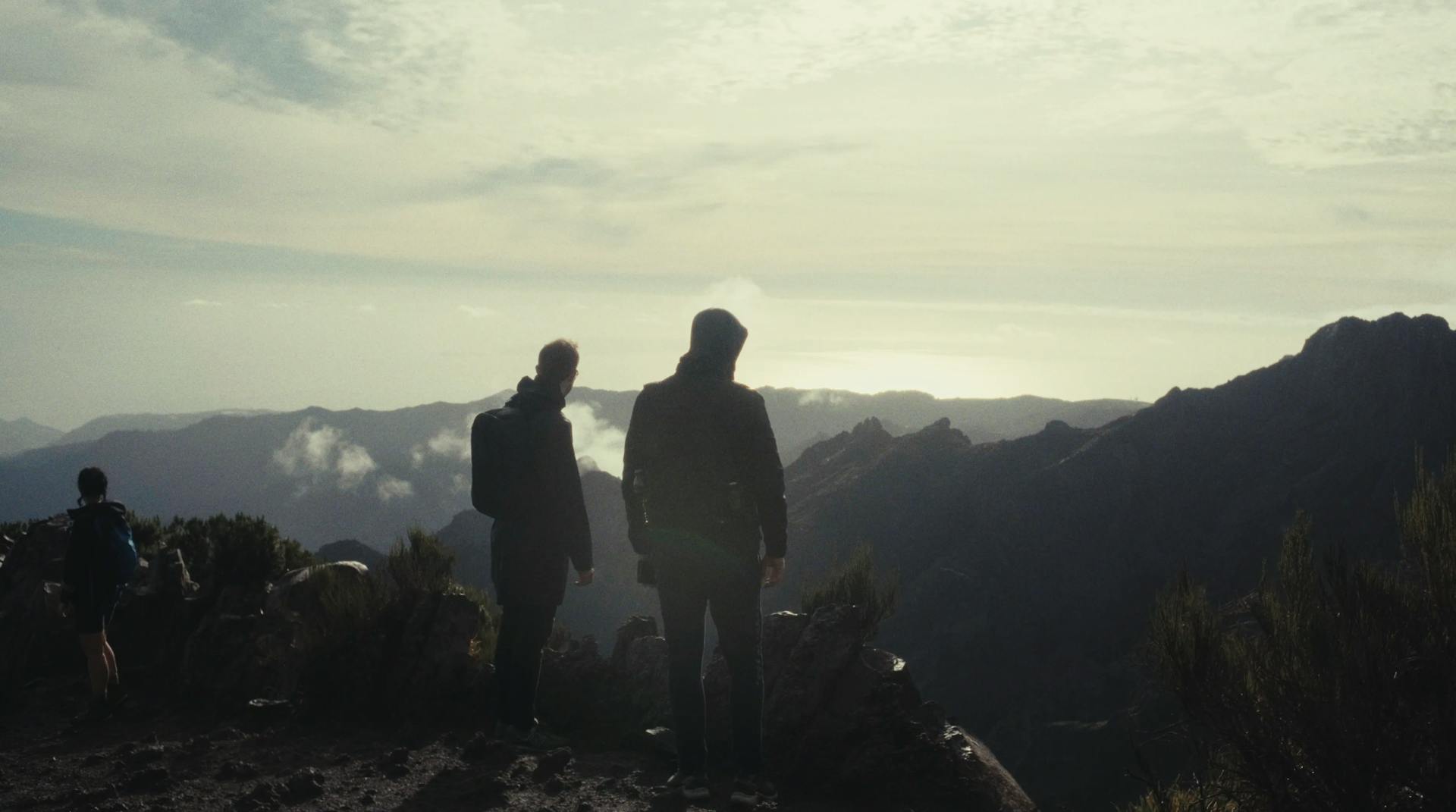 a couple of people standing on top of a mountain