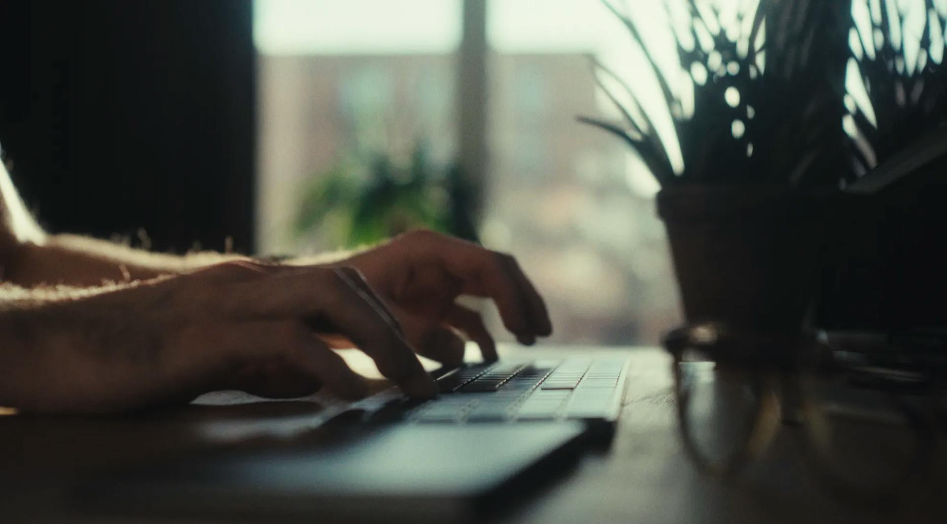 a person typing on a laptop on a table