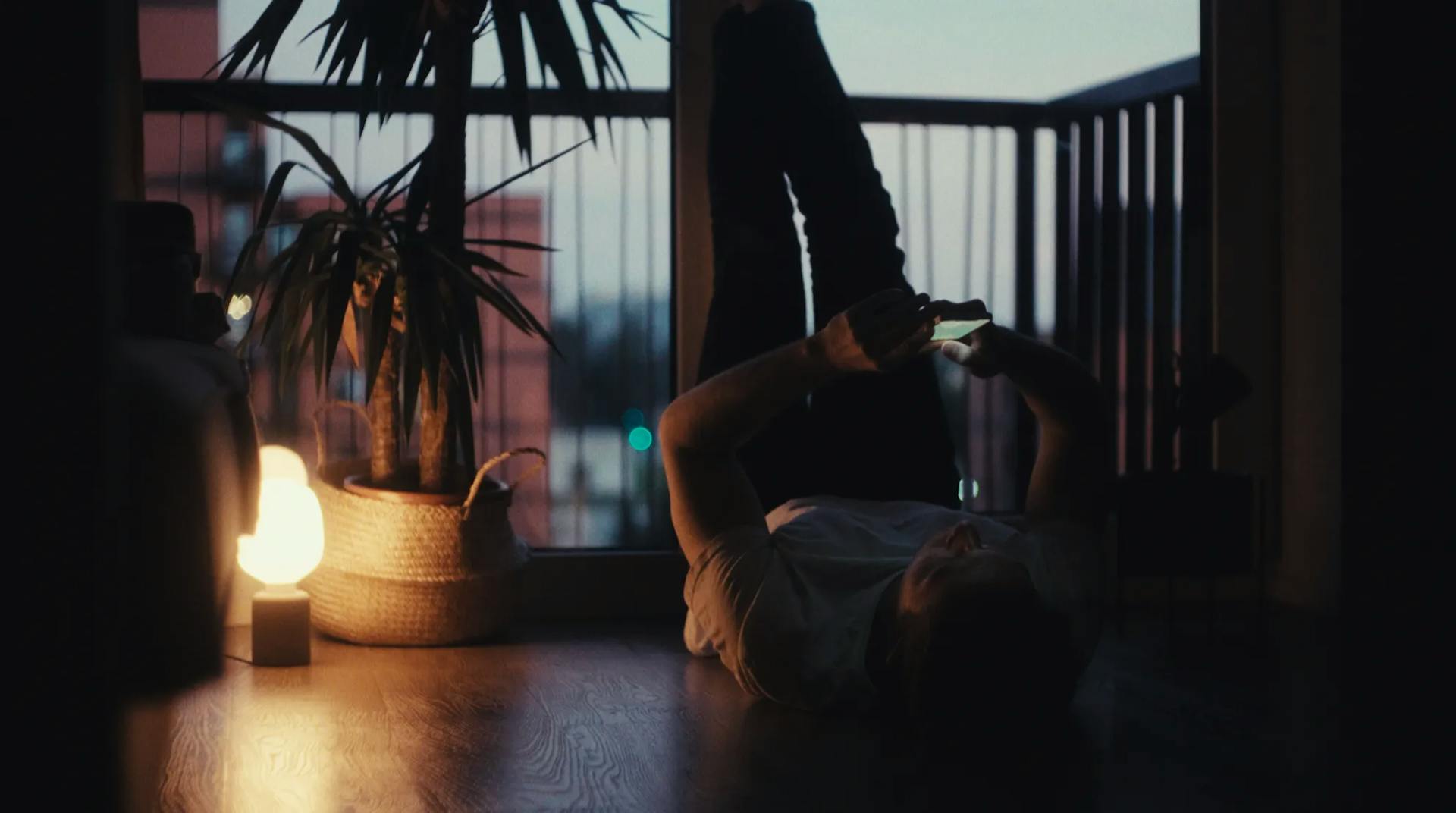 a person standing on their back on a wooden floor in front of a window