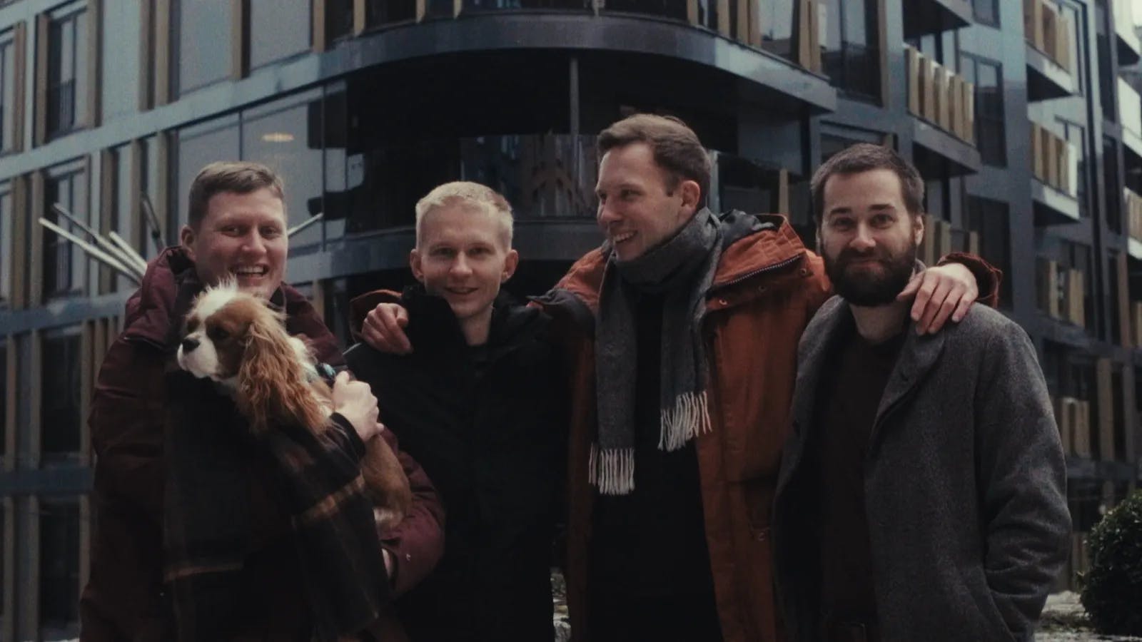 a group of men standing next to each other in front of a tall building