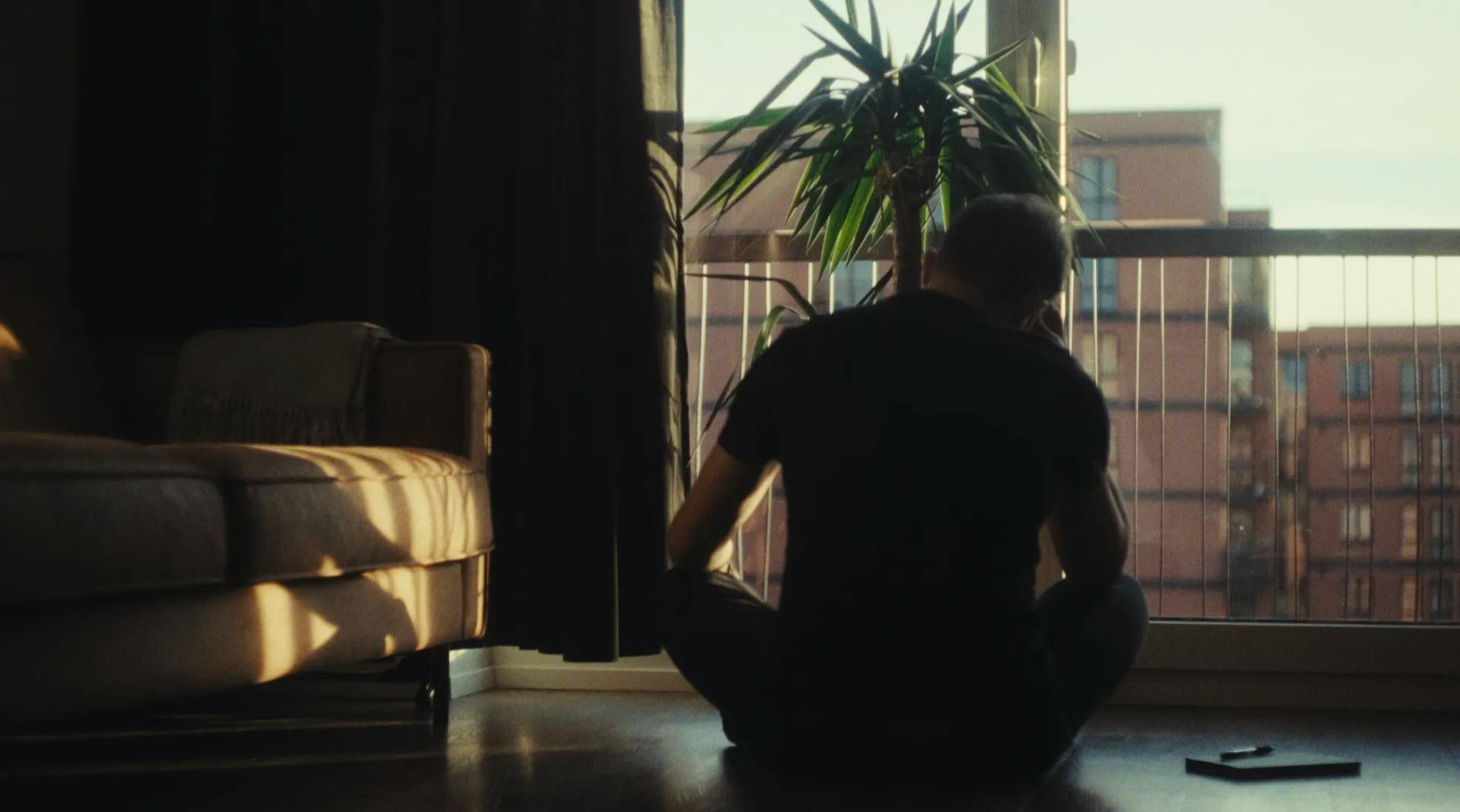 a man sitting on the floor in front of a window