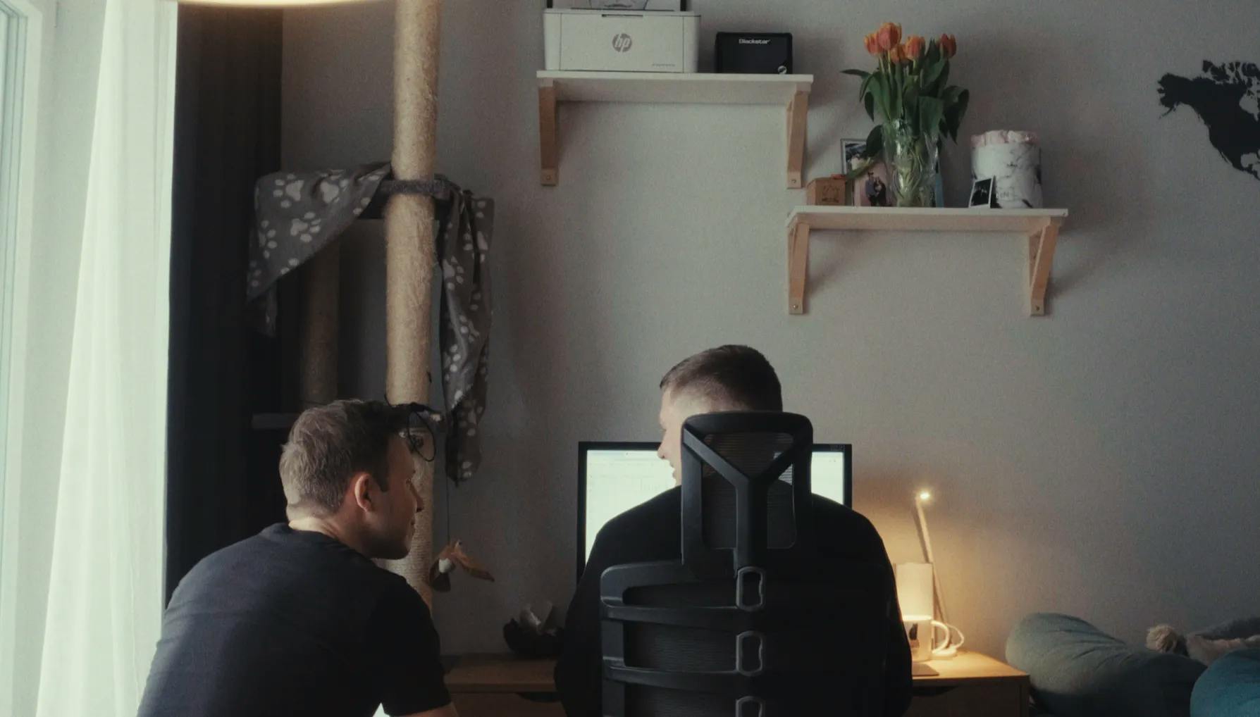 a couple of men sitting in front of a computer