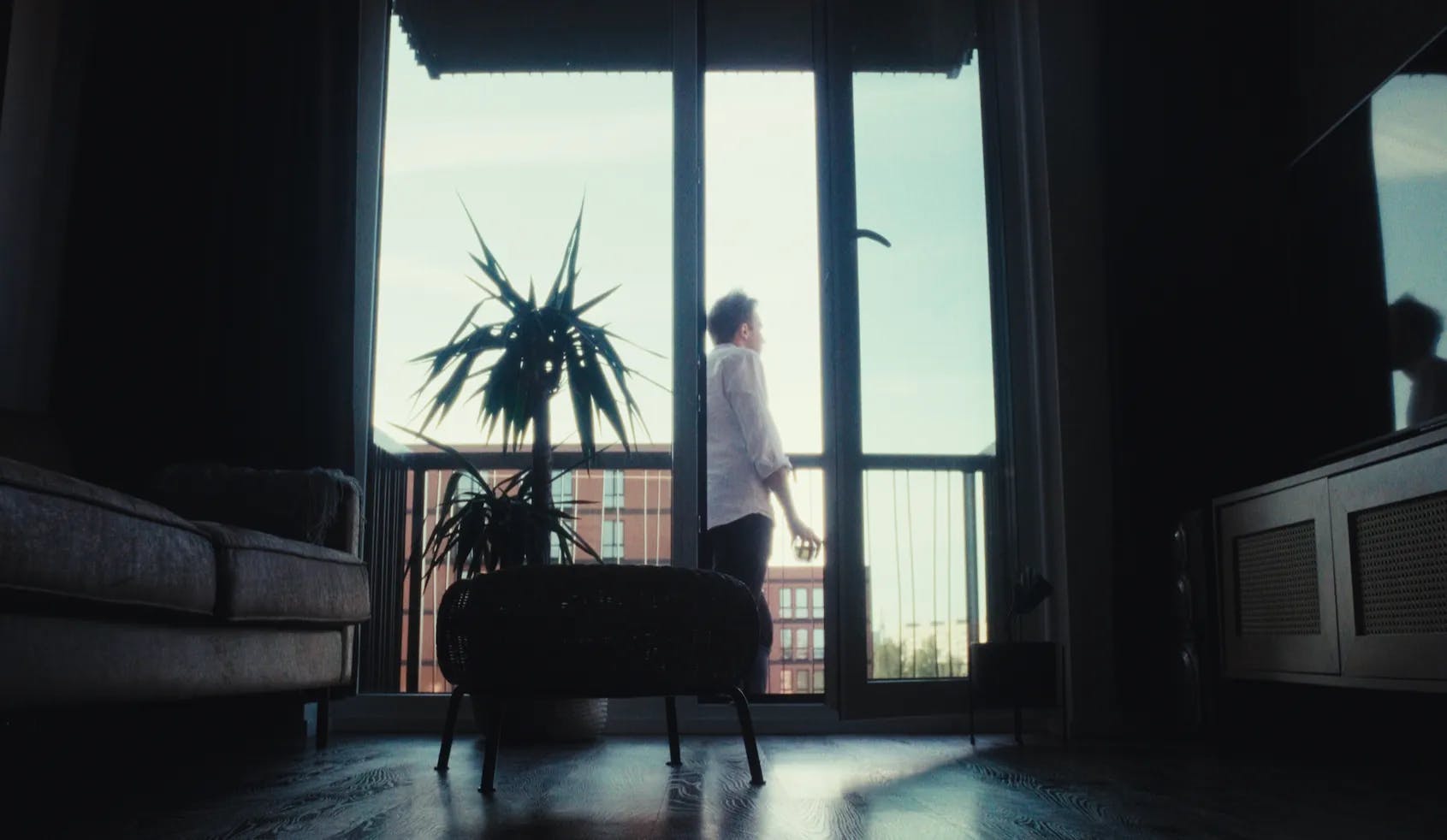 a person standing in front of a window in a living room