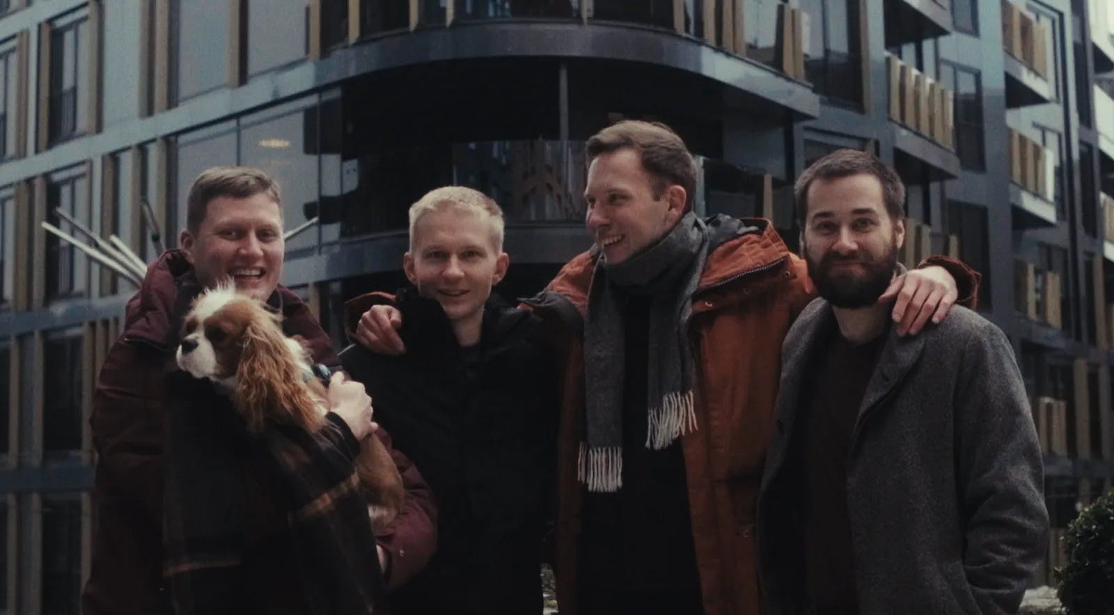 a group of men standing next to each other in front of a tall building